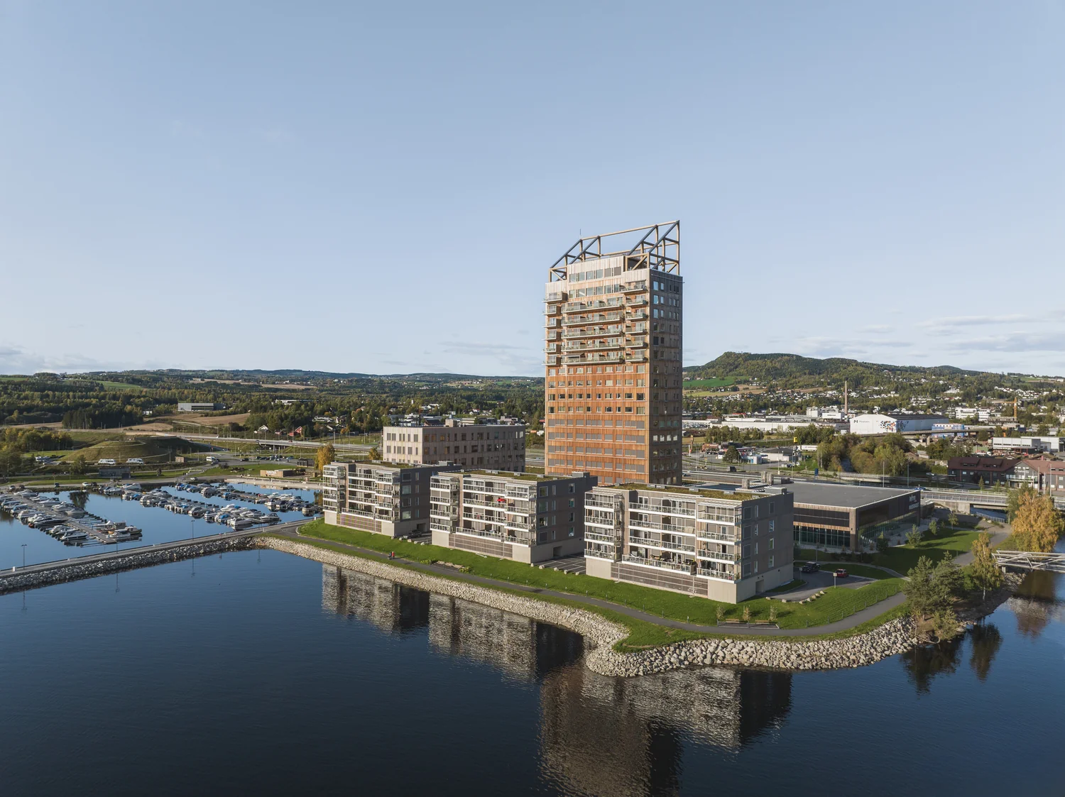 Aerial hotel view showing waterfront setting and urban context Drone view of a hotel by the water with a cityscape