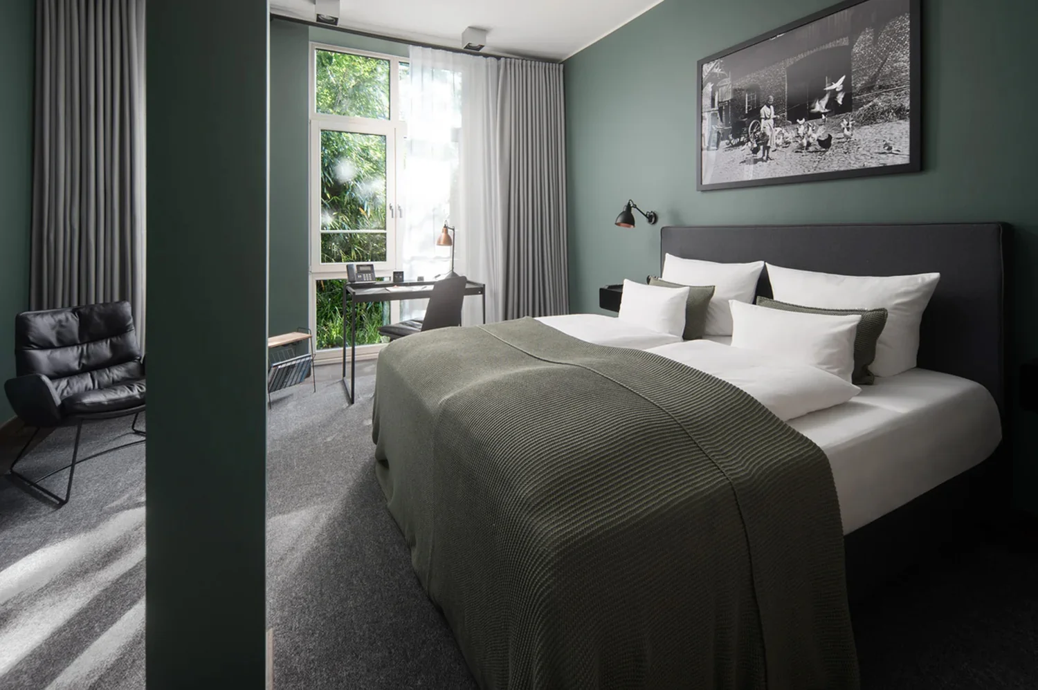 Hotel room photography with a strong focus on layout and light Modern hotel room with double bed, stylish interior, desk by the window and natural daylight