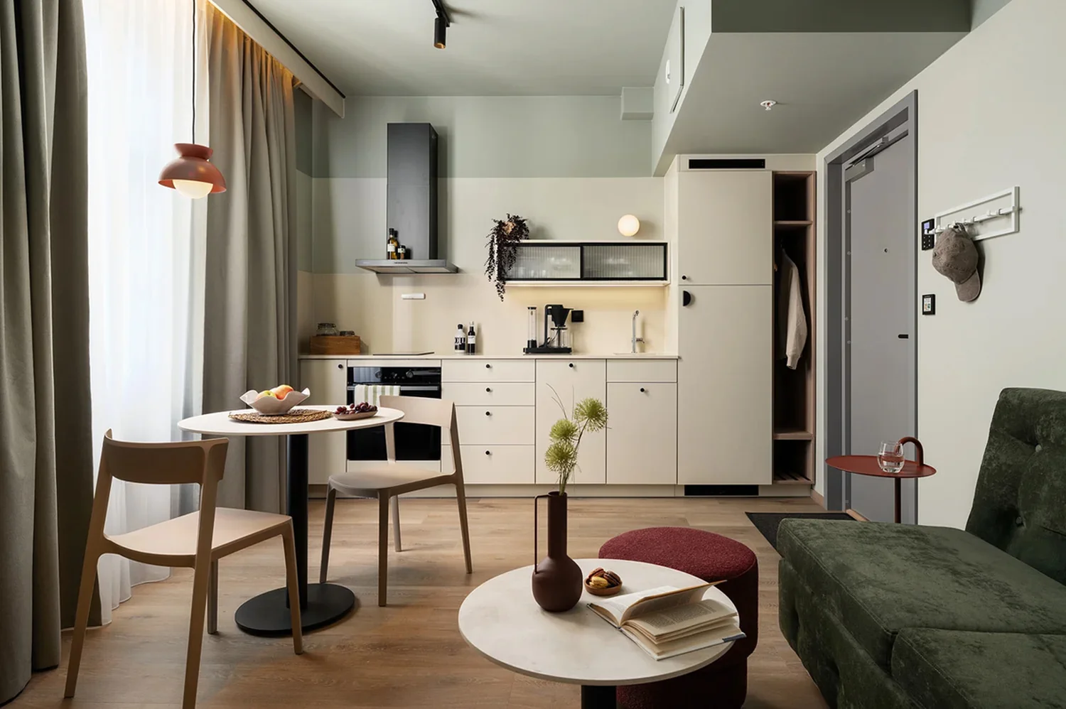 Hotel apartment interior with clear lines and practical design features Modern hotel apartment with kitchenette, dining area and stylish interior