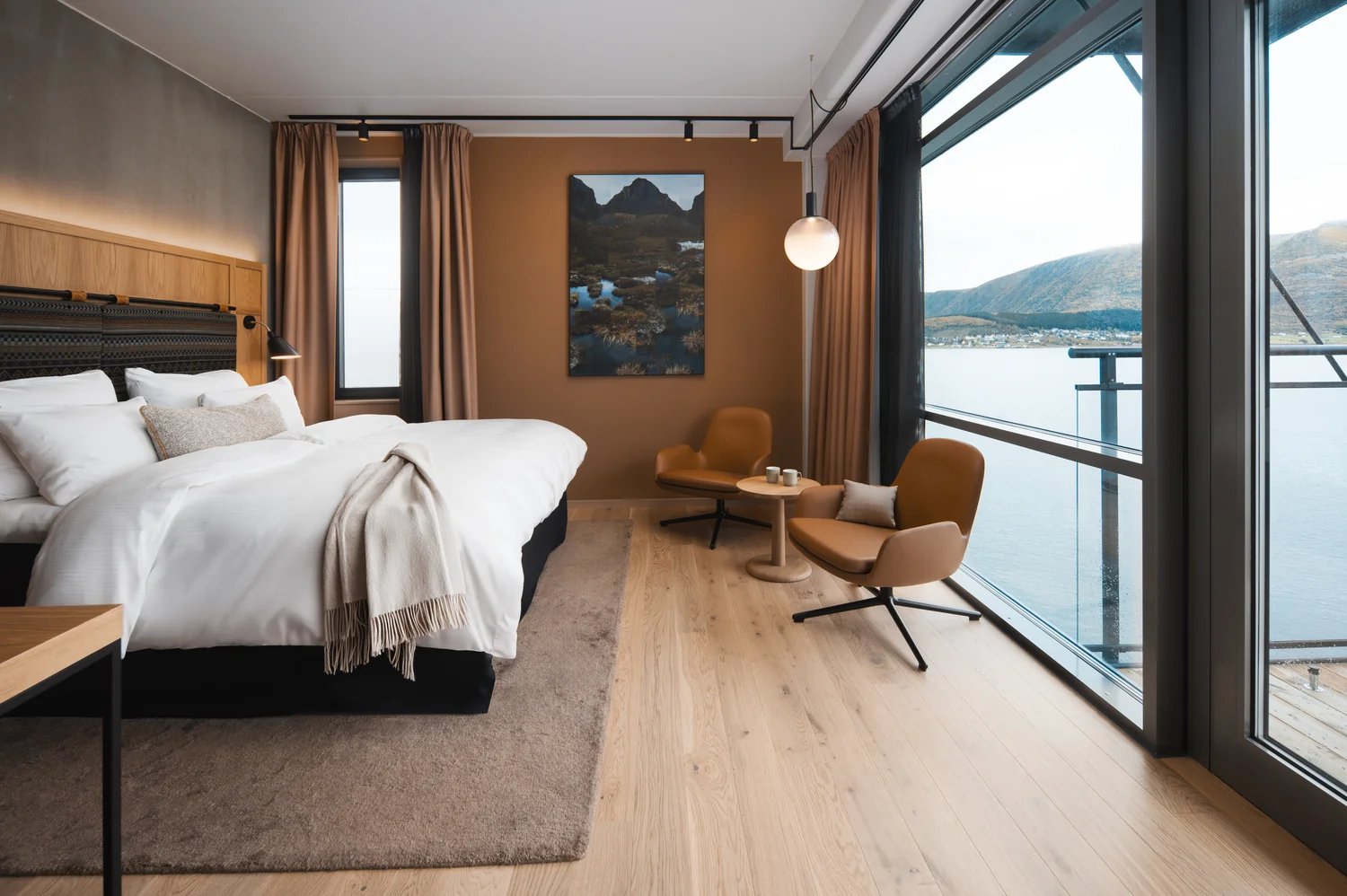 Hotel room with sea view photographed to highlight comfort and atmosphere Modern hotel room with balcony and sea view, stylish seating area and warm interior