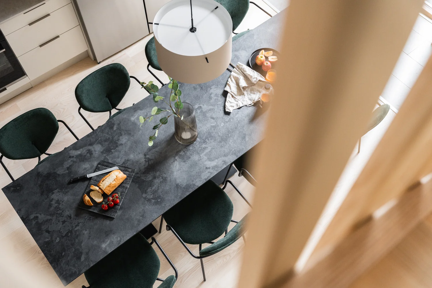 Hotel apartment dining area styled for a polished hospitality presentation Modern hotel apartment with dining area, designer kitchen and elegantly set table