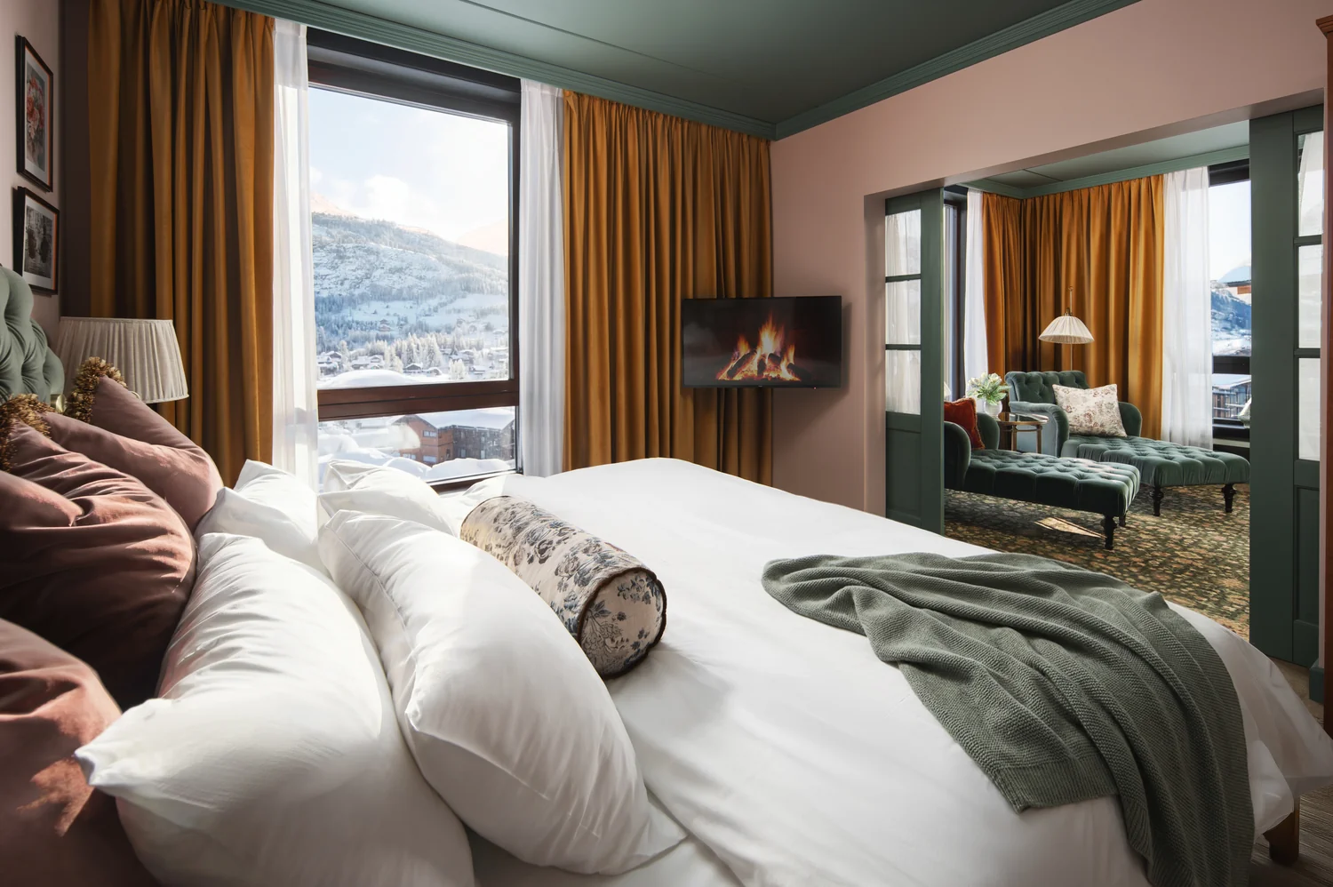 Hotel in snowy mountains at dusk with warmly lit rooms